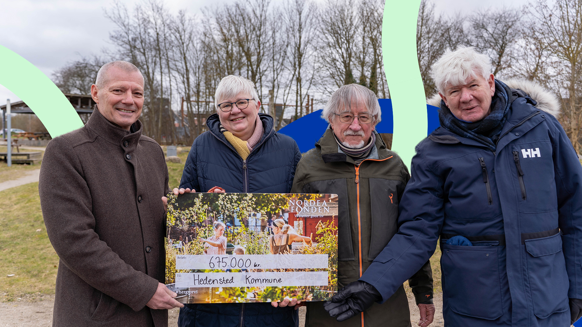 Et billede med borgmesteren og tre personer fra borgergruppen bag Trykkeriparken, der holder en check fra Nordeafonden på 675.000 kroner, som er øremærket udviklingen i Trykkeriparken.