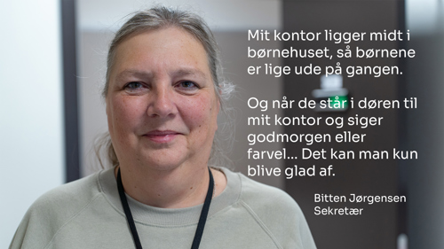 Portrætbillede af en sekretær i børnehuset, Bitten Jørgensen, der siger følgende: "Mit kontor ligger midt i børnehuset, så børnene er lige ude på gangen. Og når de står i døren i midt kontor godmorgen eller farvel... Det kan man kun blive glad af".